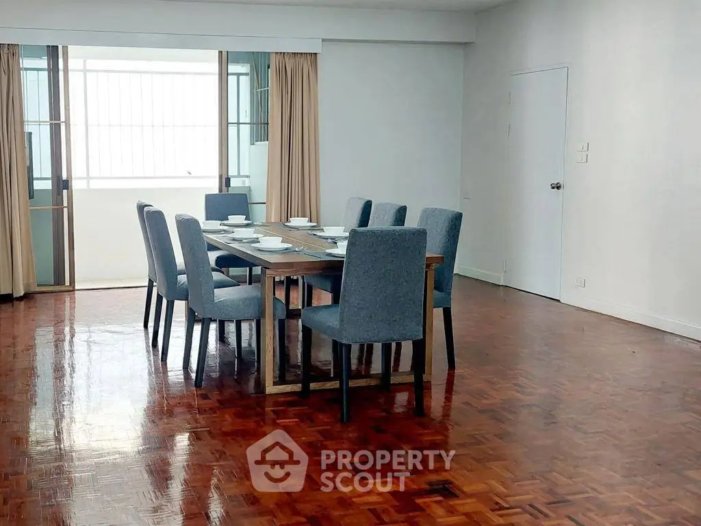 Spacious dining area with elegant wooden flooring and ample natural light.