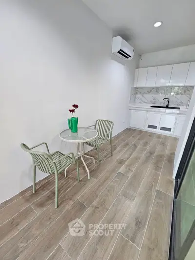 Chic modern kitchen with open layout and stylish dining area, featuring sleek cabinetry and elegant flooring.