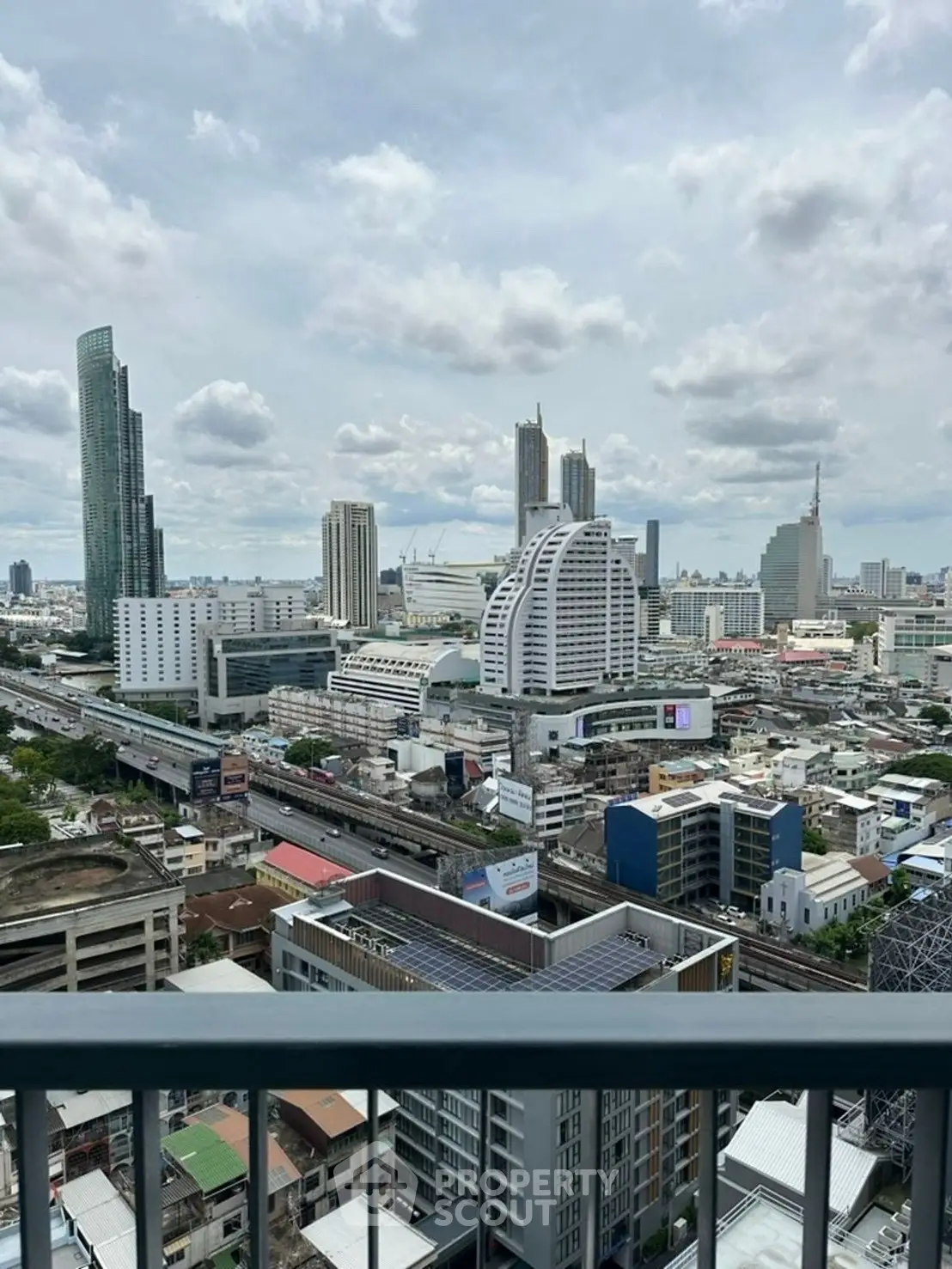 Stunning cityscape view from a high-rise balcony with modern skyscrapers and urban skyline.