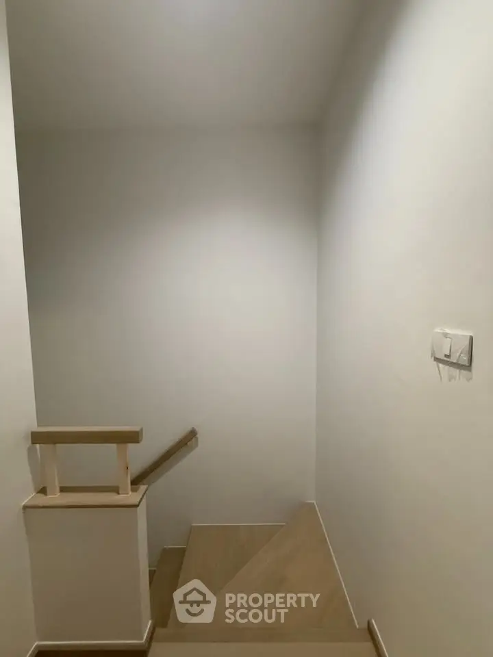 Minimalist staircase with wooden steps and white walls in modern home