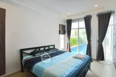 Spacious bedroom with pool view and modern decor, perfect for relaxation and comfort.