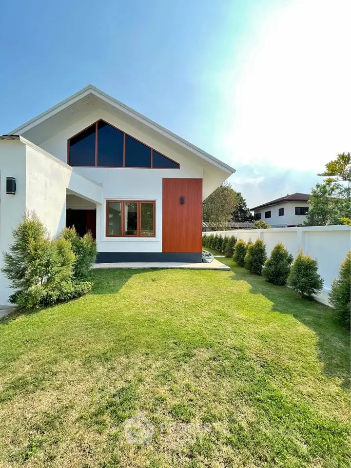 Modern house exterior with lush green lawn and contemporary design