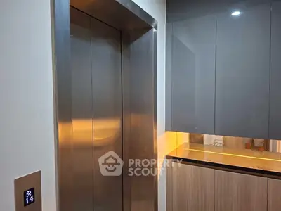 Modern elevator entrance with sleek design and ambient lighting in a contemporary building.