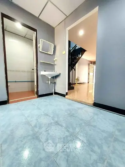 Spacious interior with blue tiled flooring and modern fixtures, showcasing a versatile open layout.