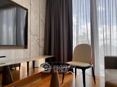 Stylish living room with modern furniture and large window offering city views.