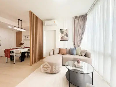 Modern living room with elegant decor and natural light, featuring a cozy sofa and stylish dining area.