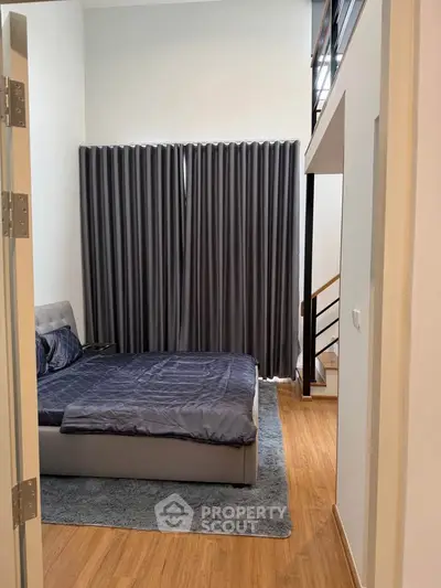 Modern bedroom with stylish decor and wooden flooring in a contemporary apartment.