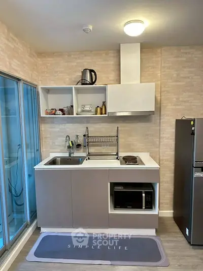 Modern compact kitchen with sleek cabinetry and appliances, perfect for urban living.