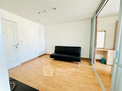 Modern minimalist living room with sleek black sofa and wooden flooring