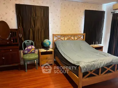 Charming bedroom with wooden furniture and cozy decor, perfect for relaxation.