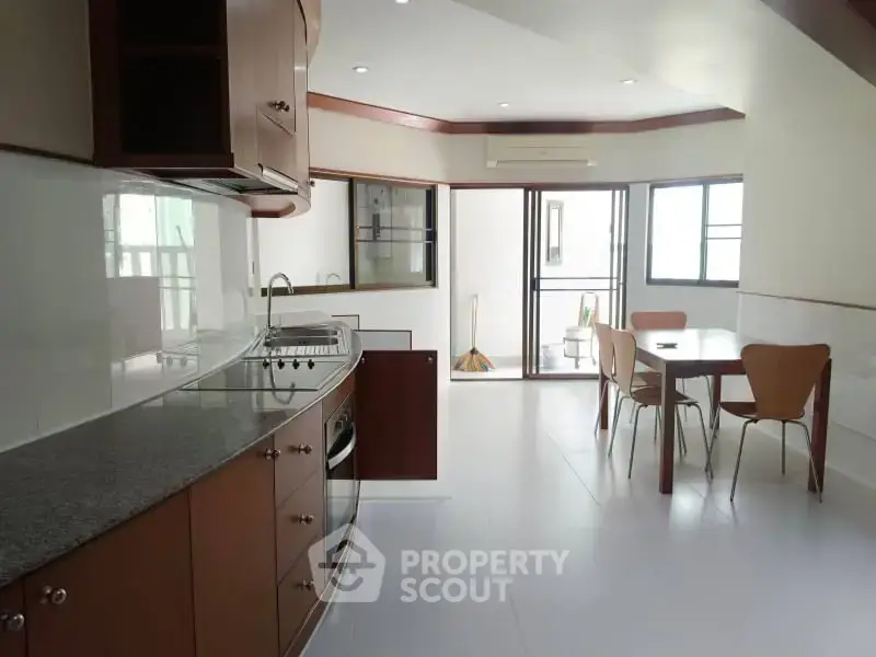 Spacious kitchen with modern appliances and dining area in a bright, open layout.