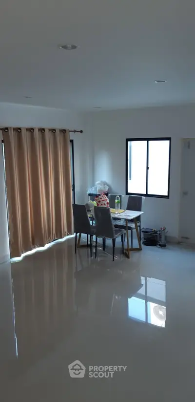 Spacious dining area with natural light and modern furnishings in a cozy apartment.