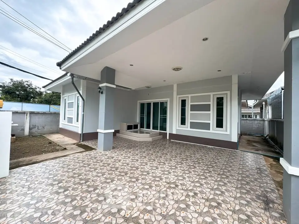 Spacious modern home exterior with tiled driveway and covered patio