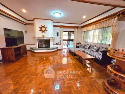 Spacious living room with polished wood floors and cozy fireplace