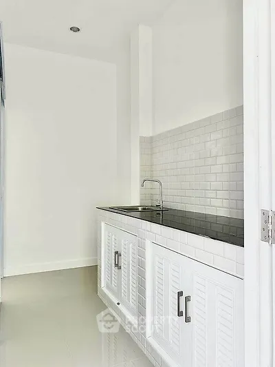 Sleek modern kitchen with white cabinetry and subway tile backsplash, perfect for contemporary living.