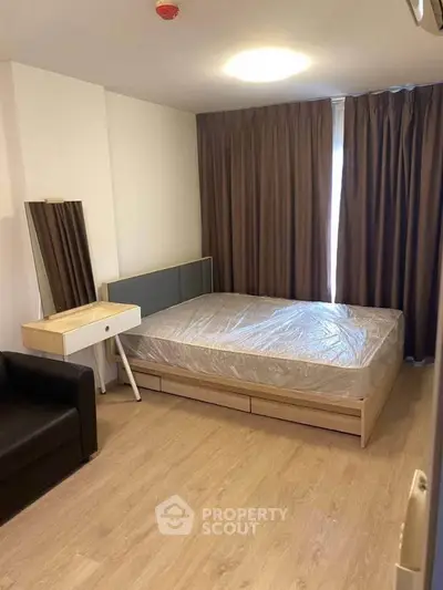 Modern bedroom with sleek furniture and natural light, perfect for cozy living.