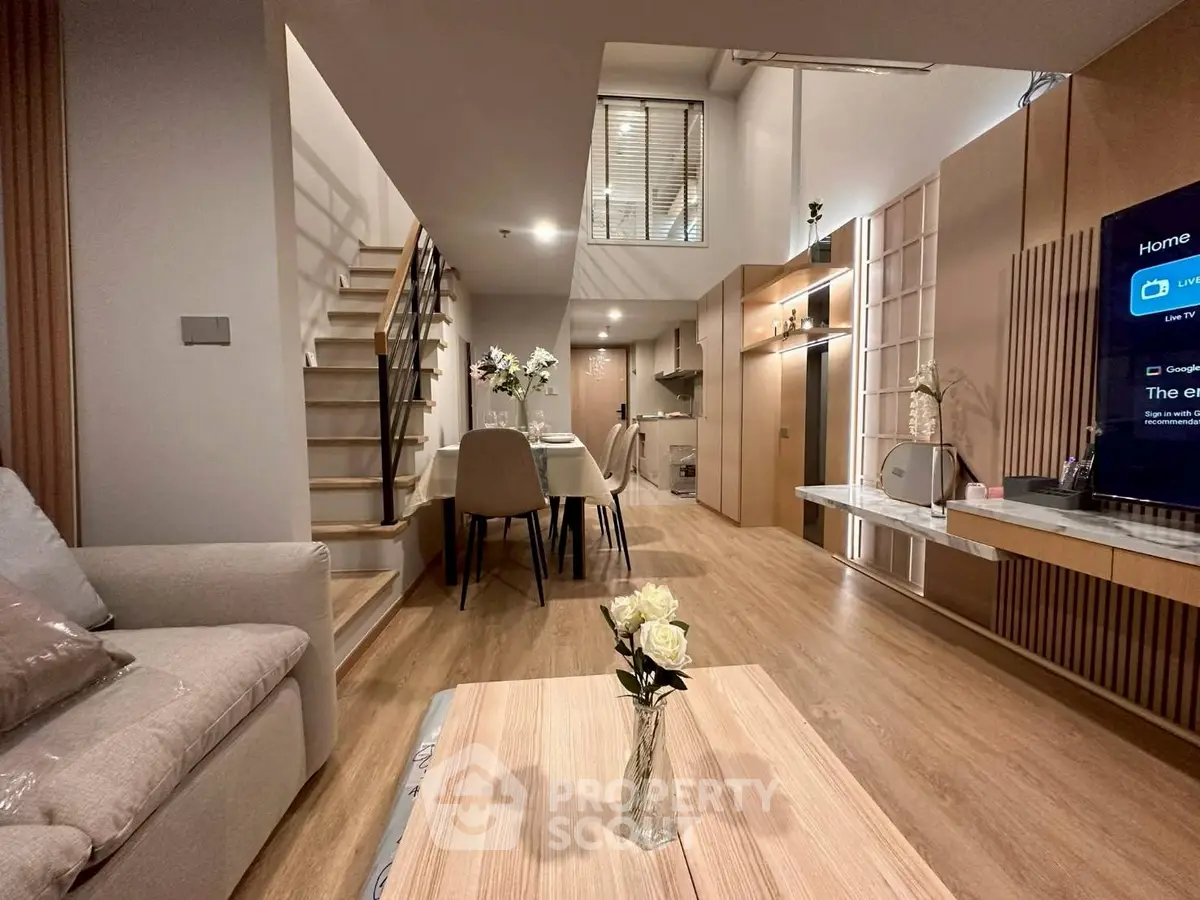 Modern duplex living room with stylish decor and open kitchen layout