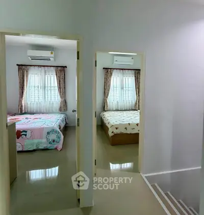 Spacious dual-bedroom setup with air conditioning and natural light, perfect for comfortable living.