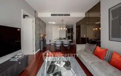 Luxurious modern living room with elegant decor and dining area, featuring hardwood floors and stylish lighting.