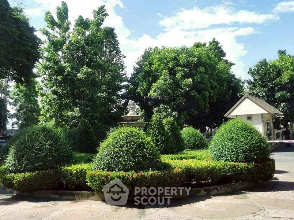 Lush garden with manicured shrubs and trees in a serene residential setting.