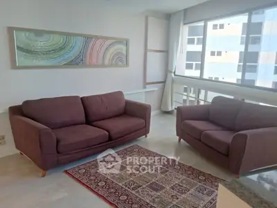 Spacious living room with modern sofas and large window view