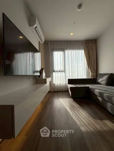 Modern living room with large window, sleek furniture, and wall-mounted TV, perfect for cozy relaxation.