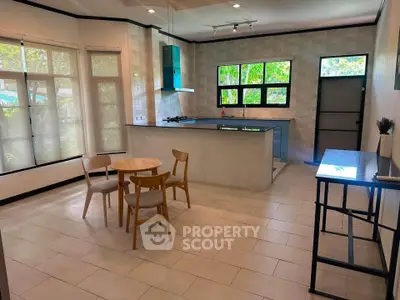 Spacious kitchen with modern design and natural light, featuring open layout and stylish dining area.