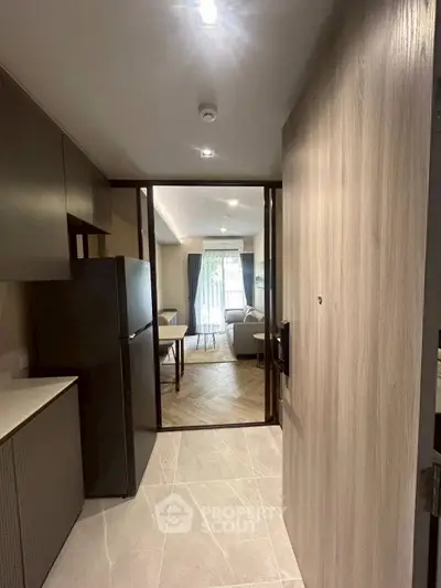 Modern apartment entrance leading to a cozy living room with stylish decor and natural light.