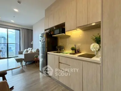 Modern open-layout kitchen with sleek cabinetry and cozy living area in a high-rise apartment.