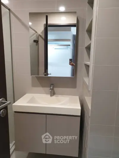 Modern bathroom with sleek vanity and mirror in a contemporary apartment.