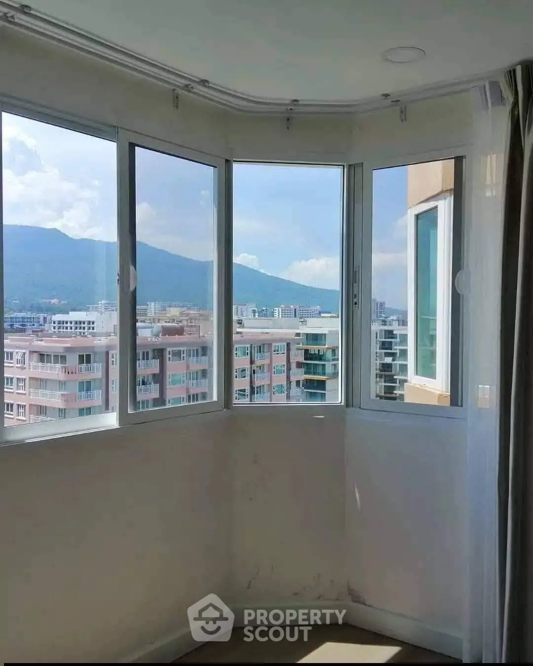 Stunning corner unit with panoramic city and mountain views through large windows.