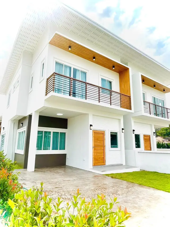 Modern duplex with stylish facade and lush greenery, perfect for contemporary living.