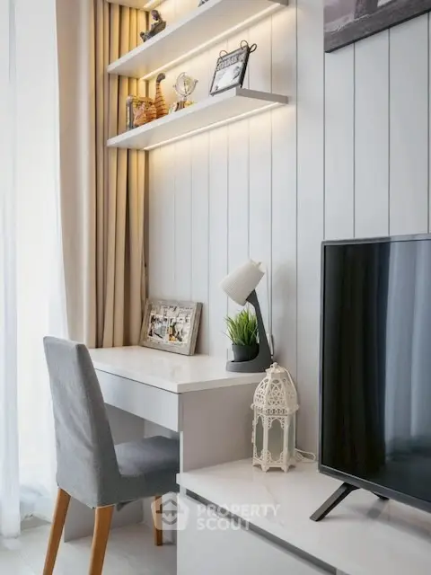 Modern study area with sleek desk, chair, and TV in stylish apartment.