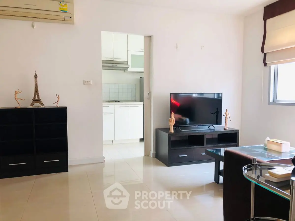 Modern living room with sleek furniture and open kitchen view, perfect for urban living.