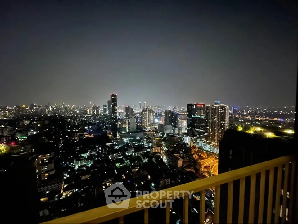 Stunning city skyline view from high-rise balcony at night, perfect for urban living enthusiasts.
