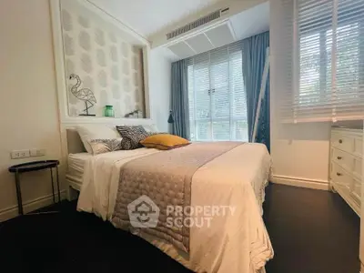 Charming bedroom with elegant decor and large windows offering natural light.