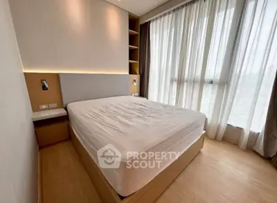 Modern bedroom with large windows and natural light in a stylish apartment.