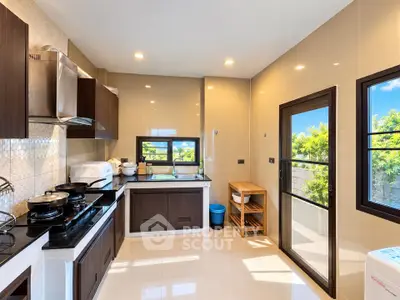 Modern kitchen with sleek cabinetry and large windows offering natural light