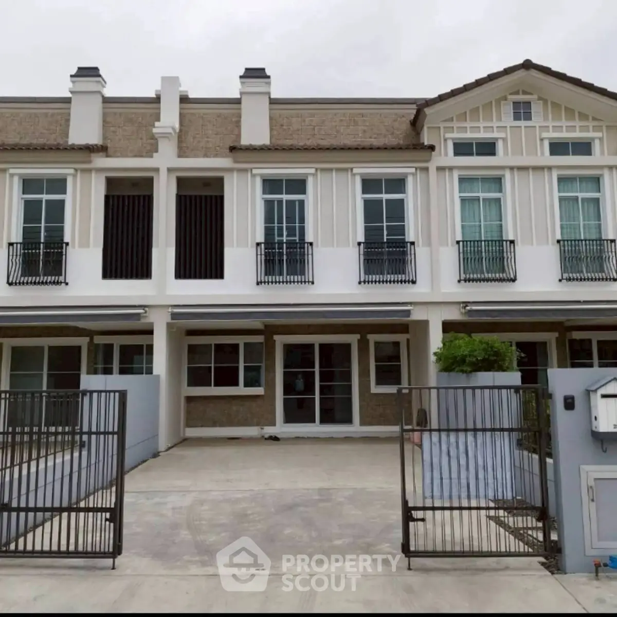 Charming townhouse exterior with modern design and spacious driveway in a serene neighborhood.