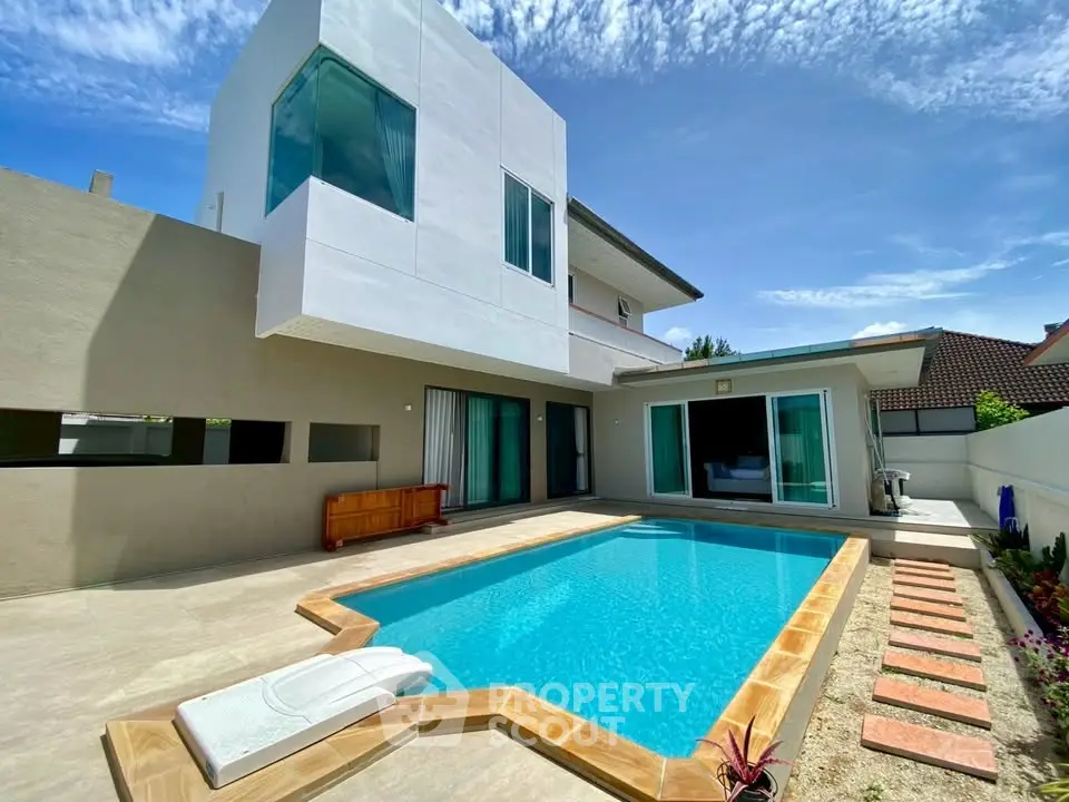 Modern luxury villa with private pool and sleek architecture under a clear blue sky.