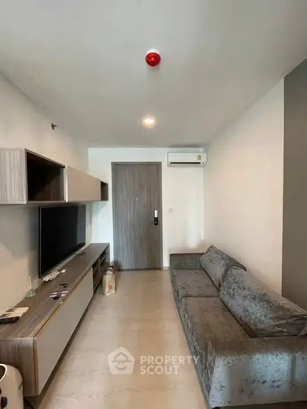 Modern living room with sleek furniture and wall-mounted TV in a stylish apartment.