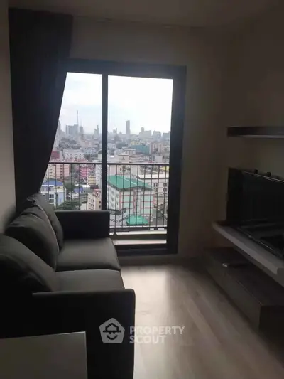 Modern living room with city view from large window, featuring sleek sofa and minimalist decor.