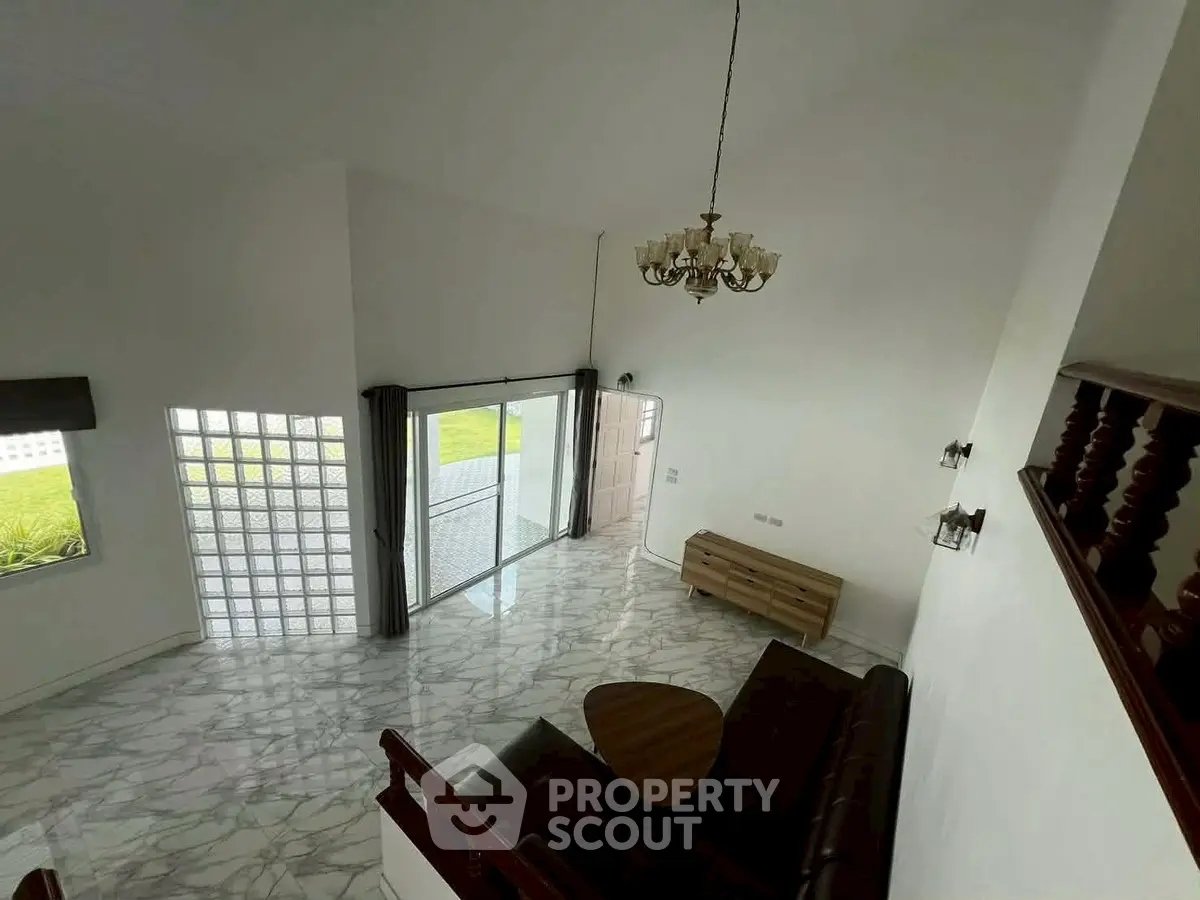 Spacious living room with high ceiling and elegant chandelier