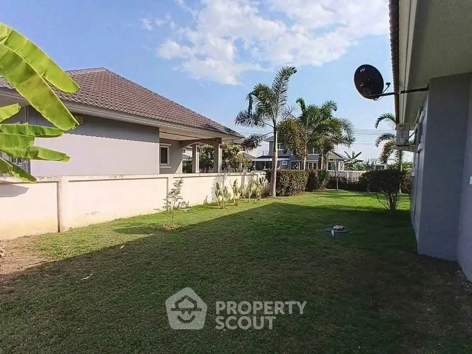 Spacious garden area with lush greenery and modern house exterior