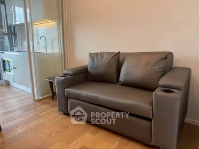 Modern living room with sleek sofa and open kitchen layout, perfect for urban living.