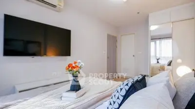 Modern bedroom with cozy decor and wall-mounted TV, perfect for relaxation.