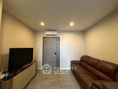 Modern living room with sleek design, featuring a leather sofa and flat-screen TV, perfect for relaxation.