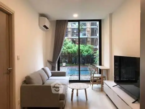 Modern living room with pool view, stylish furniture, and large window.