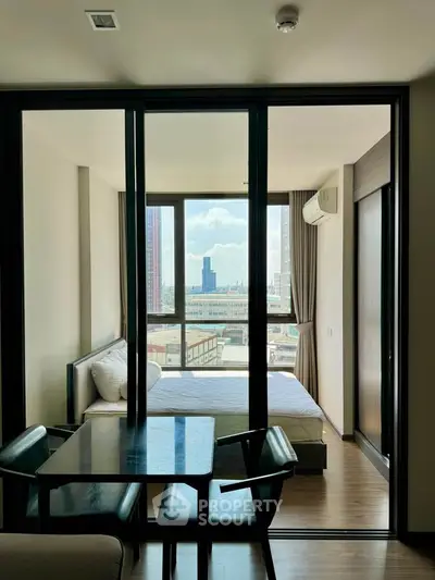 Modern bedroom with city view and glass partition in stylish apartment
