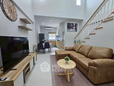 Spacious living room with modern decor and open kitchen layout in a stylish home.